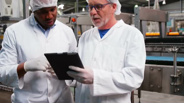 Workers discussing over digital tablet
