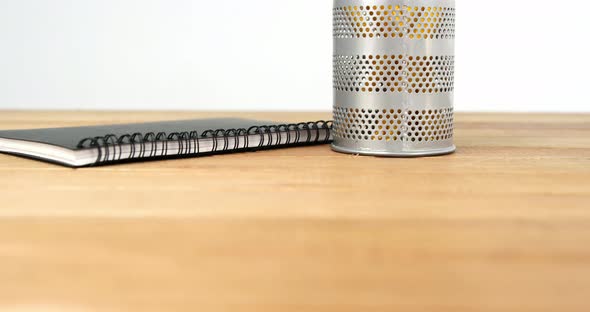 Close-up of pen holder with pencil and diary