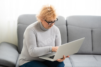 Video call. Good-looking elderly lady i having a video call on laptop