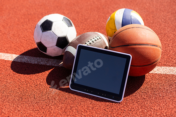 balls and tablet computer on color background. Concept of sports bet