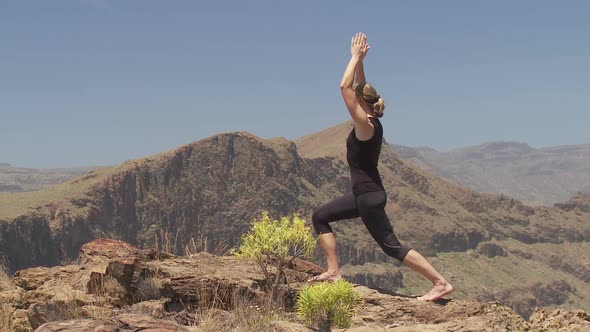 Dolly Shot of Woman Exercising High up in Rocky Mountains