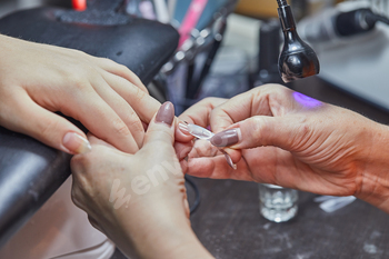 Nail Technician Applying Extension at Salon