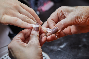 Nail Technician Applying Extension at Salon