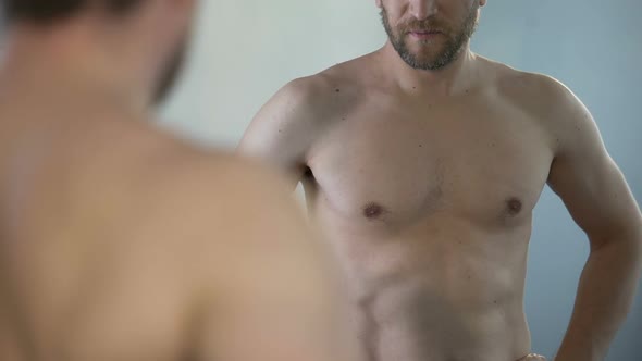 Guy Examining His Reflection in Mirror Thinking About Old Age and Men's Health