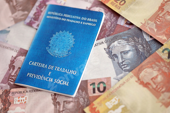 Brazilian work card and social security blue book and reais money bills