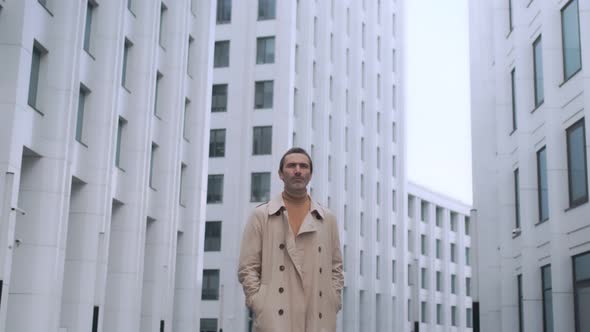 Portrait of an adult successful businessman looking around. Serious business man standing outdoors.