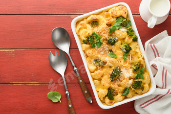 Casserole Mac and cheese. Baked Mac and cheese with broccoli, cream sauce and parmesan on red old ru