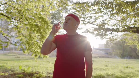 Senior Old Man Running in Park and Using Smart Watch, Tracking Result After Fitness Workout