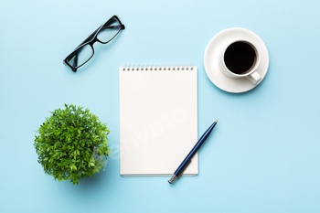 Modern office desk table with notebook and other supplies with cup of coffee. Blank notebook