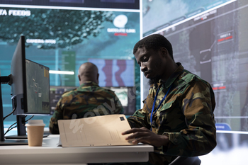 Military man in command center uses advanced technology and classified documents