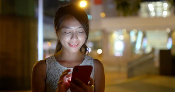 Woman use of mobile phone online at night