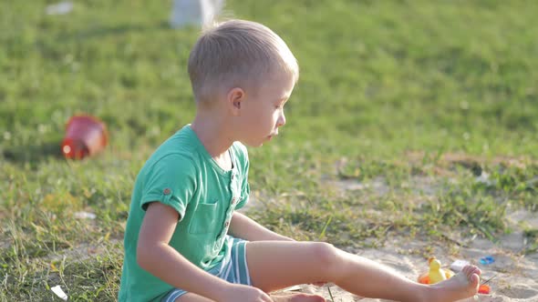 Boy Plays Sand Toys Outdoors