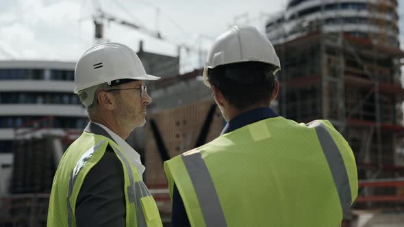 Two Builders Controlling Working Process on Construction Site