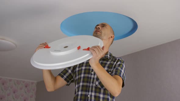 A Man Installs a Modern Led Ceiling Light on the Ceiling