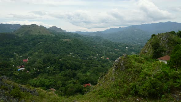 Green mountain cliffs overlooking a city in the valley of Tana Toraja in Sulawesi Indonesia.