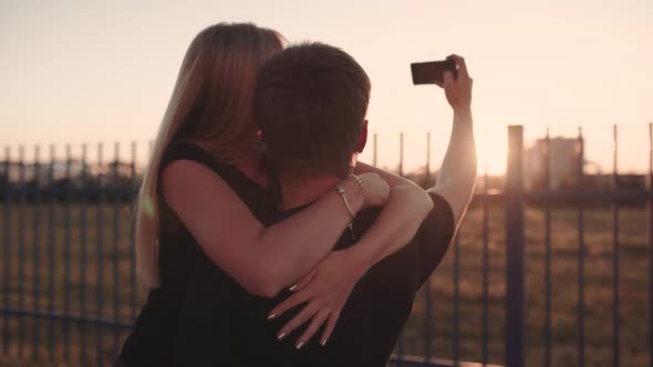 An Attractive Couple in Love Embrace and Enjoy an Intimate Moment Together Against the Sunset or