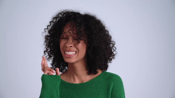 Happy curly-haired woman hoping for something