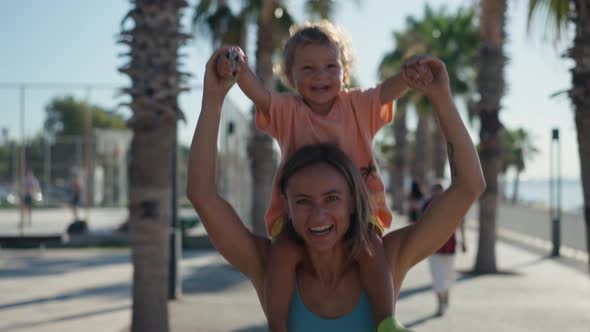 Baby Sitting on Mother Shoulders Outside at Park