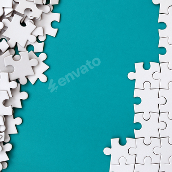 Fragment of a folded white jigsaw puzzle and a pile of uncombed puzzle elements