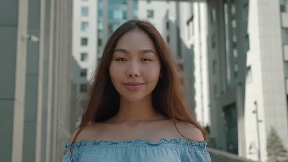 Smiling Asian Young Woman in with Bare Shoulders Outfit Looking to Camera Outside on Street Feel