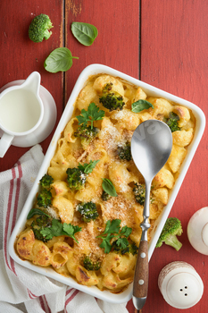 Casserole Mac and cheese. Baked Mac and cheese with broccoli, cream sauce and parmesan on red old ru