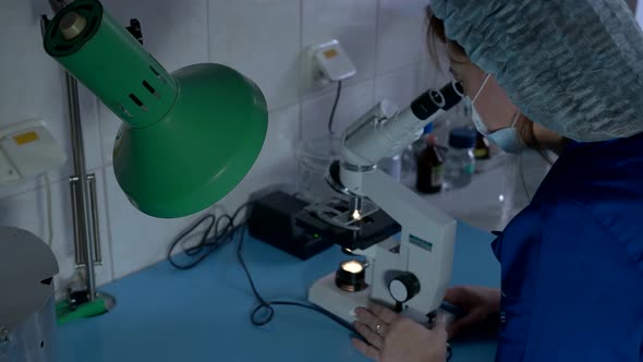 Woman Looking Into Microscope.