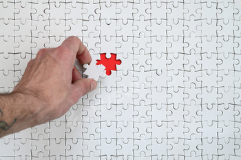 The texture of a white puzzle puzzle in the assembled state with one missing element