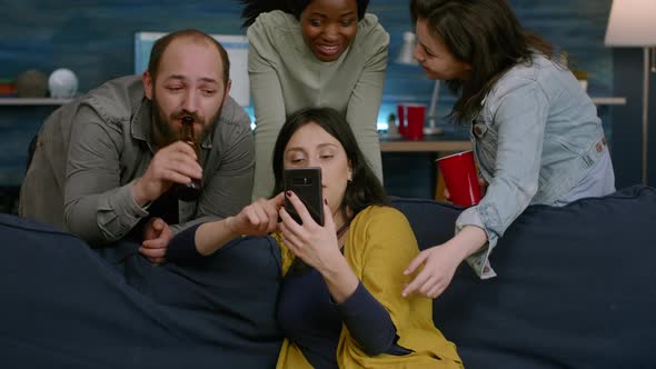 Woman Showing Comedy Video to Her Multiracial Friends Socializing Together