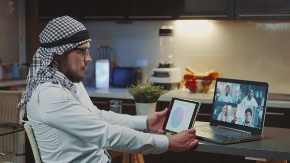 Arabic Man with Kandora Having Online Video Conference with Multiracial Doctors From Around the