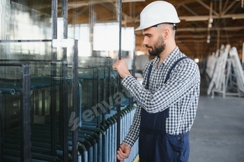 The glazier carries the glass in the glass factory.