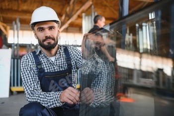 The glazier carries the glass in the glass factory.