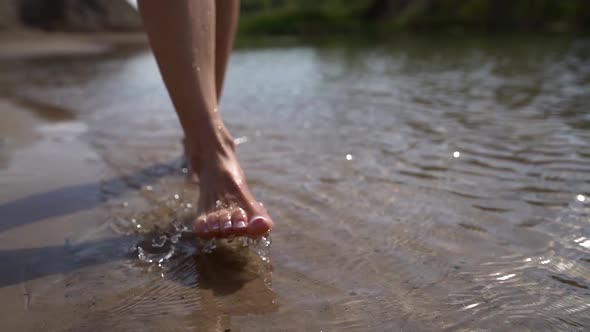 Female Feet in Water of Shallow of Lake or River, Closeup View