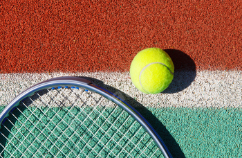 Close up of tennis racquet and ball on the tennis court