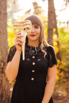 Woman in carnival mask in forest