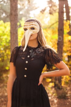 Woman in carnival mask in forest