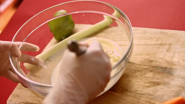 Macro View of Mixing Fresh Eggs Flour and Milk with Steel Hand Mixer in a Glass Bowl