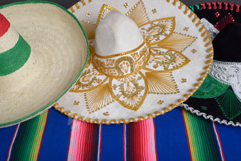 Mexican hats with the colors of the Mexican flag on a colorful serape.