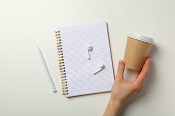 Headphones with a notebook and coffee on a white background