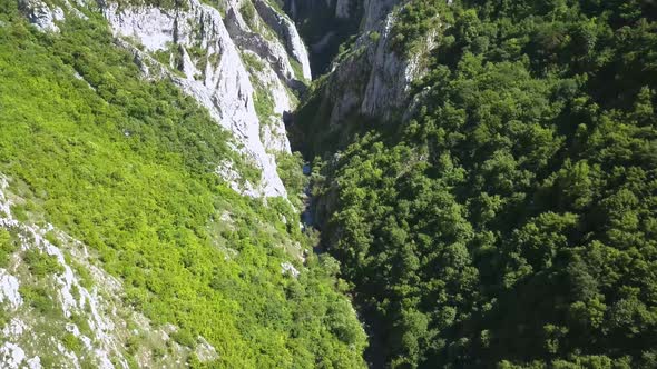 Aerial view from a drone of Turda Gorge, or Cheile Turzii, as camera tilts up to reveal some of the