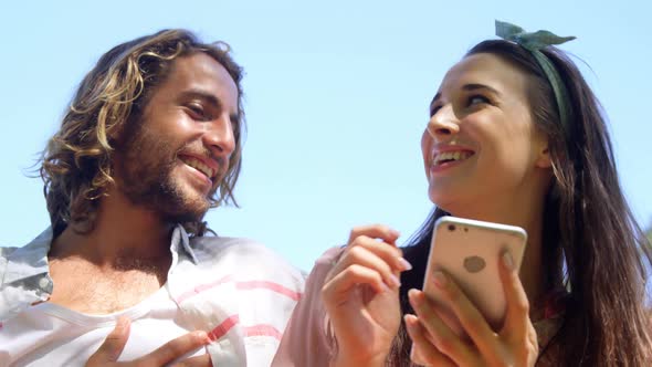 Couple laughing and watching smartphone