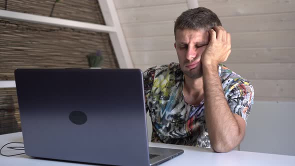 A Bored Man Looks at a Computer Screen and is Suddenly Surprised By Unexpected News