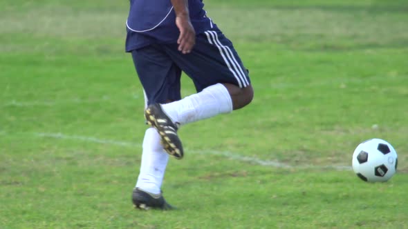 A man playing soccer on a grassy field.