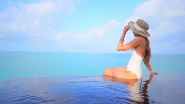 Young asian woman enjoy around outdoor swimming pool for leisure