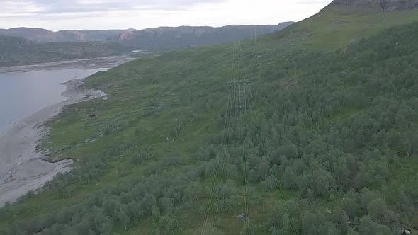 Aerial view of high voltage towers over a forest in Norway.