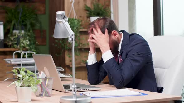 Exhausted Office Worker Sitting at His Desk