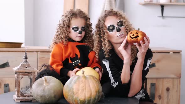 Mother and Daughter with Curly Hair Wearing Halloween Costumes