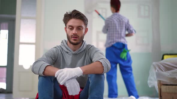 Portrait of Tired Exhausted Handsome Man Looking at Camera Sighing Holding Head in Hands