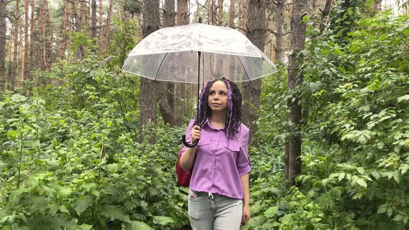 A woman with an umbrella in her hand in the rain.