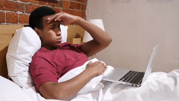 Headache, Tired African Man Working on Laptop in Bed