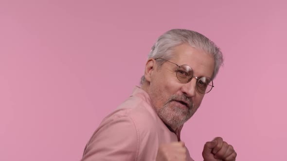 Portrait of an Elderly Man with Glasses Dances Funny Dance of Joy or Good Mood